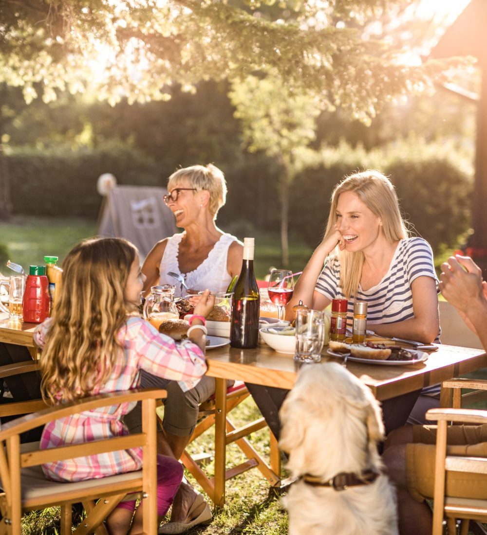 Happy multi-generation family enjoying in lunch time at their backyard.